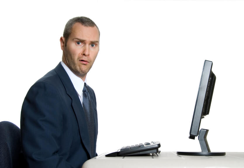 surprised man in blue suit in front of computer